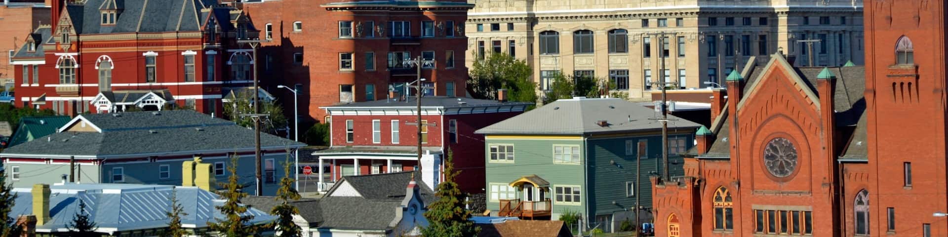 A town with historic buildings, a prominent church, and a mountainous backdrop.