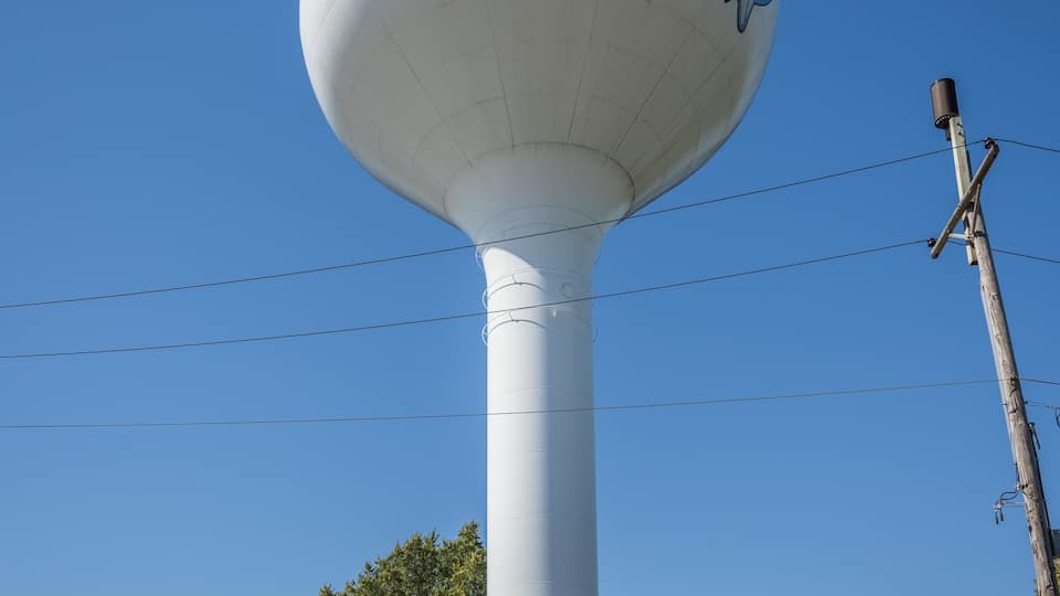 A water tower with the name "Brookfield" on a building with a brick facade and a red roof.