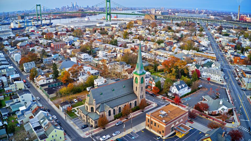 An aerial view of a city with a prominent church, a bridge, and a waterfront.