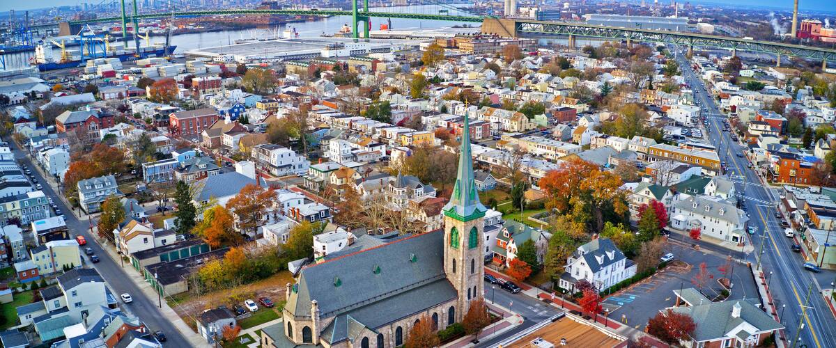 An aerial view of a city with a prominent church, a bridge, and a waterfront.