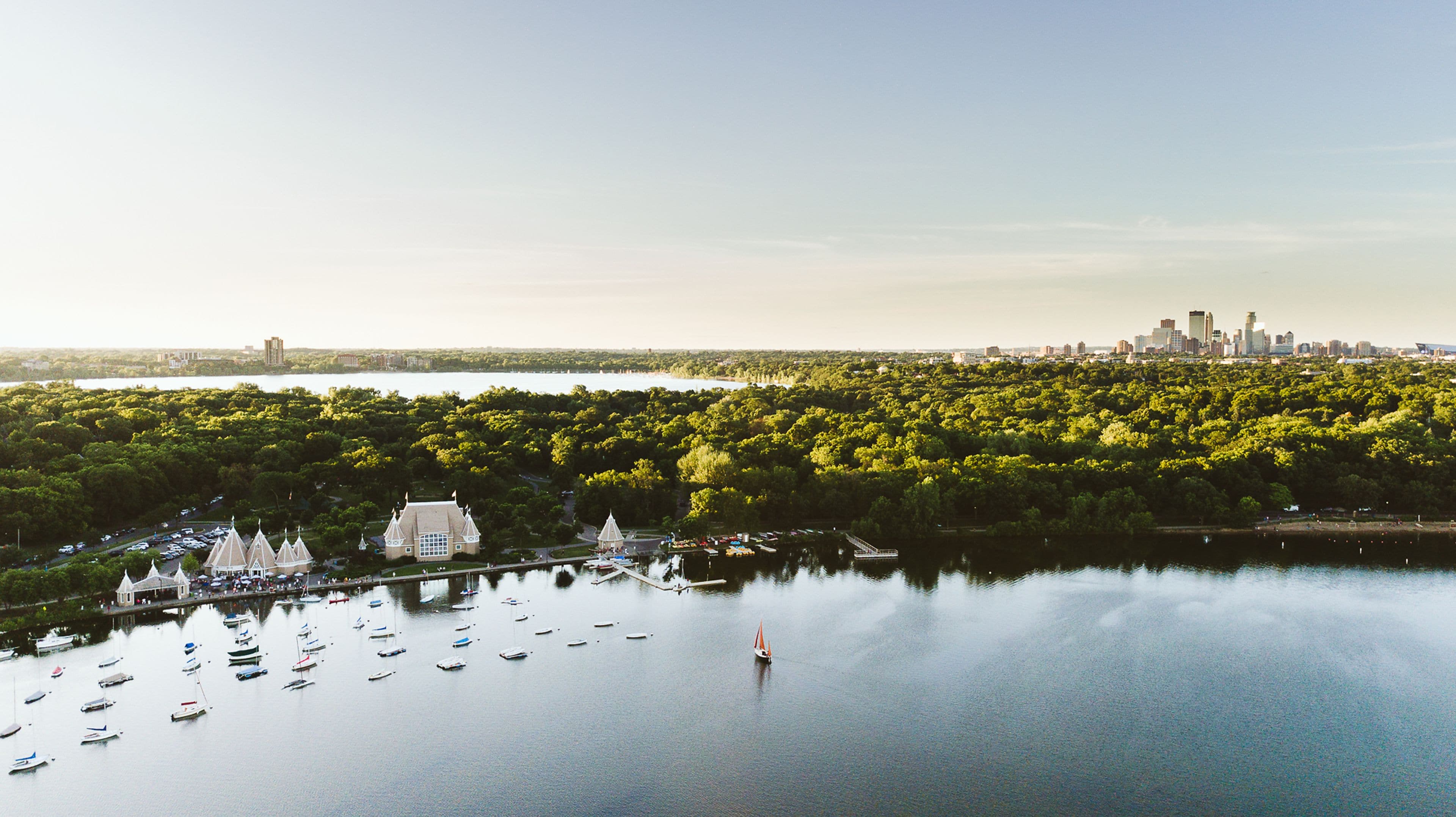 Drone shot of Lake Harriet with the Minneapolis skyline