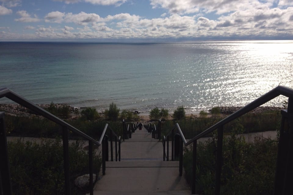 A staircase leading to a beach with a view of the ocean.