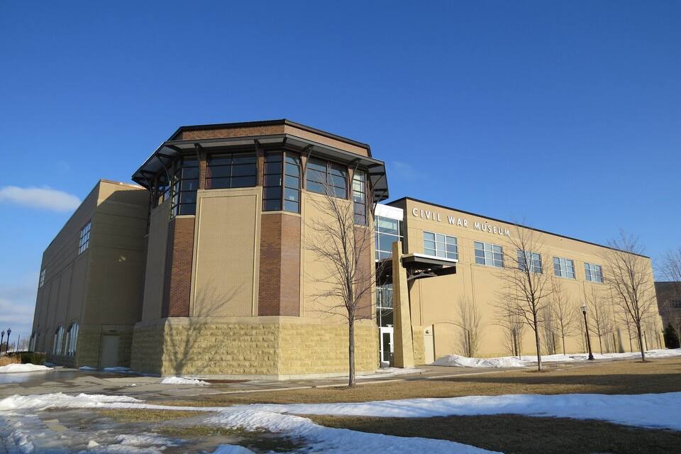 A Civil War Museum building with a beige facade, large windows, and a clear blue sky.