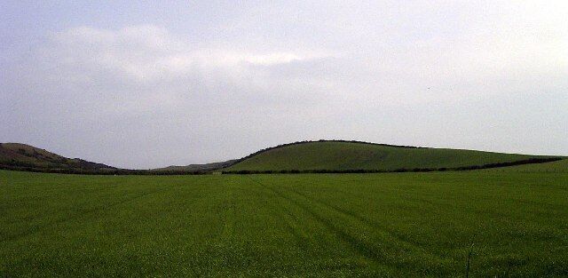 The hill north-east of Ballavair, Bride. On top of this hill is a mound which was recorded as "having been opened by boys in the 1920s". We may never know it was a Viking burial mound or something much older. The hill is next to the sea and rises to 68m, and would be ideal for a Viking burial which were often positioned with a view of the sea. This picture is taken from A10 Ramsey-Bride Road looking east.
