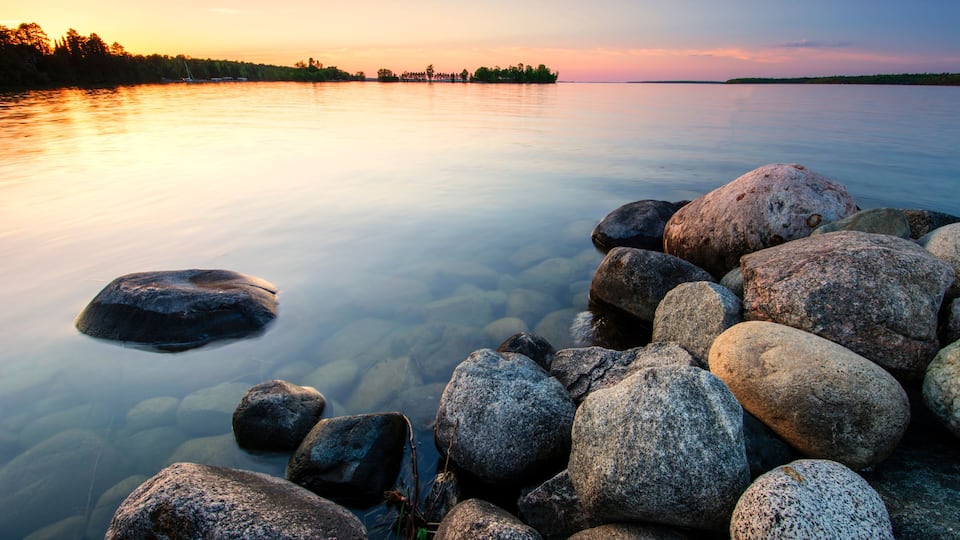 Large boulders on lake shore at sunset. Minnesota, USA