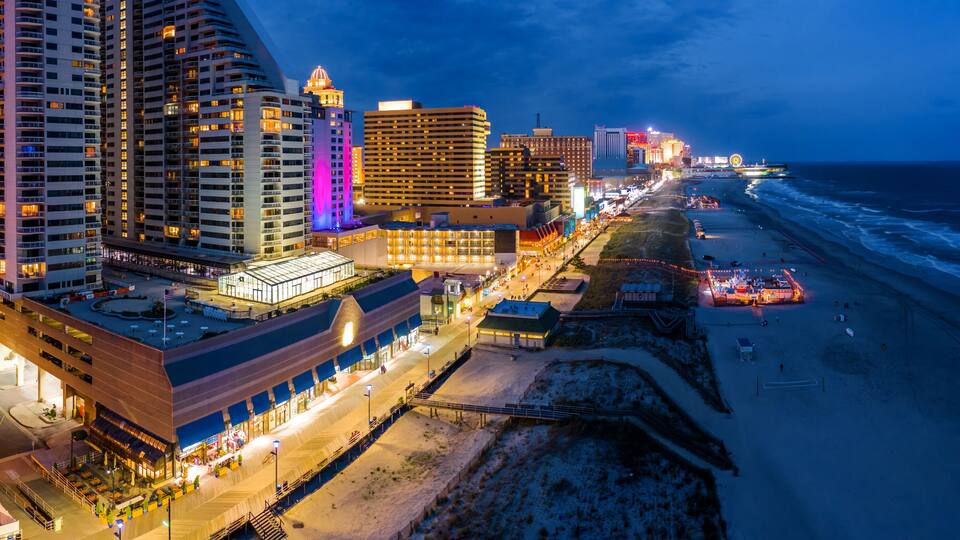 Aerial panorama of Atlantic city along the boardwalk at dusk. In the 1980s, Atlantic City achieved nationwide attention as a gambling resort and currently has nine large casinos.