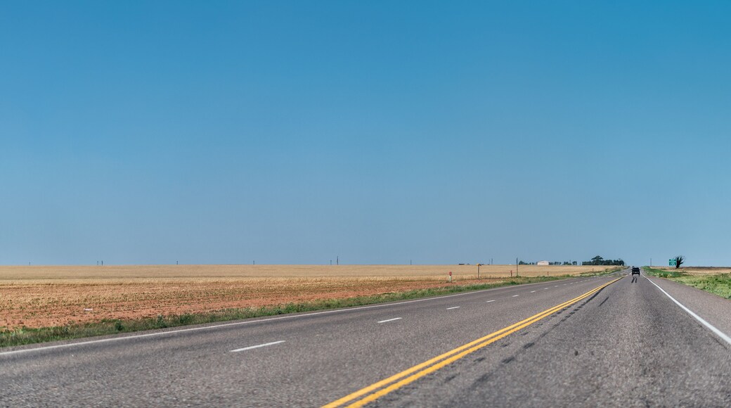 Brownfield, USA Texas countryside rural town historic farm road view from 380 highway with prairie dry grass field and blue sky