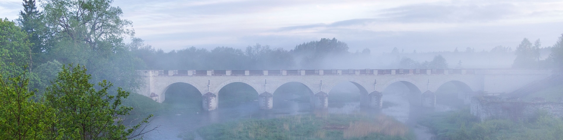 Beautiful shot of an arched bridge over a misty river in Rapla, Estonia