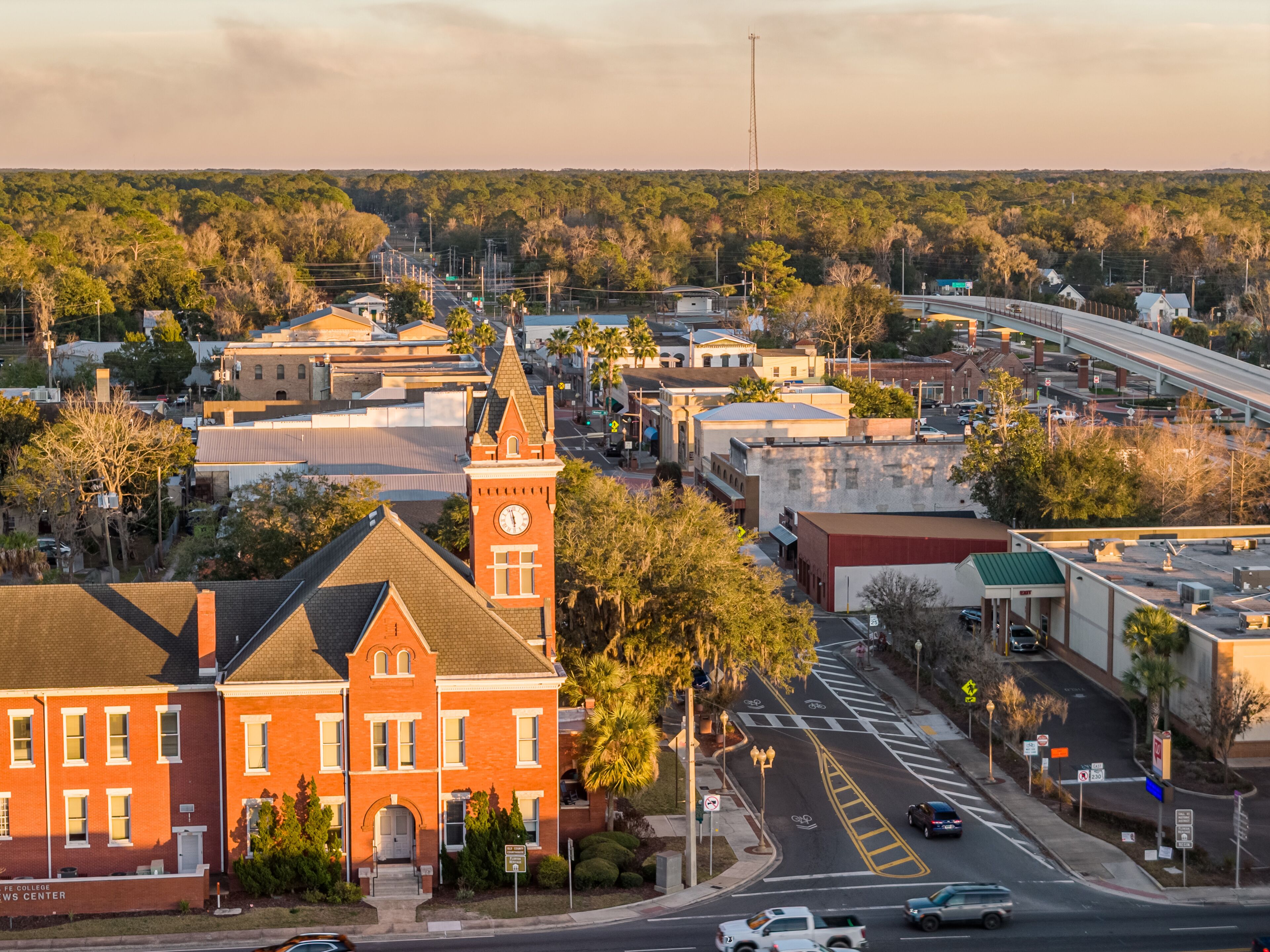 A town with a prominent clock tower, a bridge, and a mix of commercial and residential buildings.