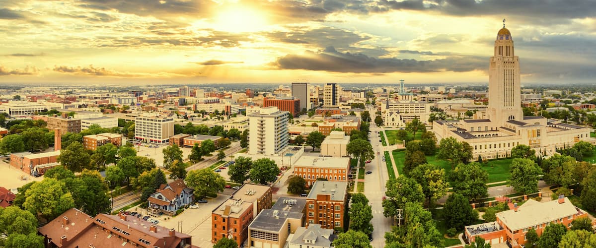A cityscape with a prominent clock tower, surrounded by various buildings and greenery.