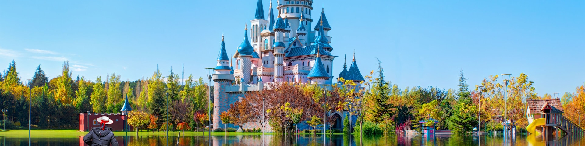 A castle with multiple towers and a gondola on a calm lake.