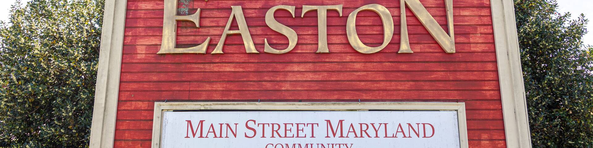 The western entrance of the historic picturesque small town of Easton, MD, center of Talbot County. A landmark with coat of arms is erected on US route 50 that says welcome to Easton.