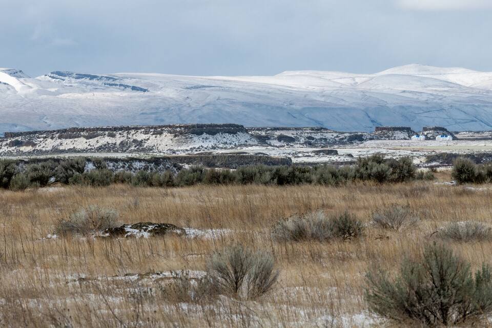 A snowy mountain range with a small settlement in the valley.