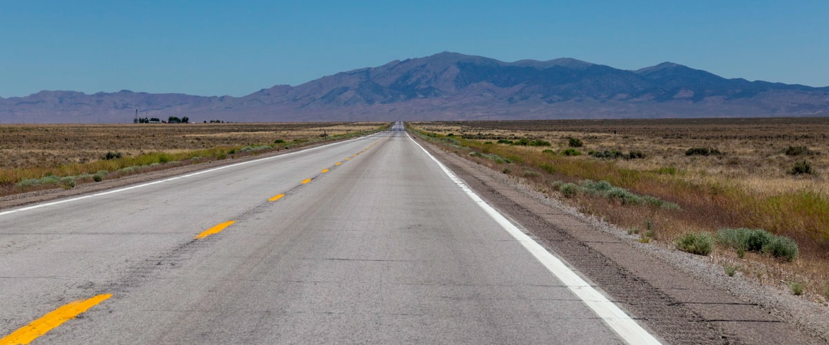 A straight road with mountains in the distance.