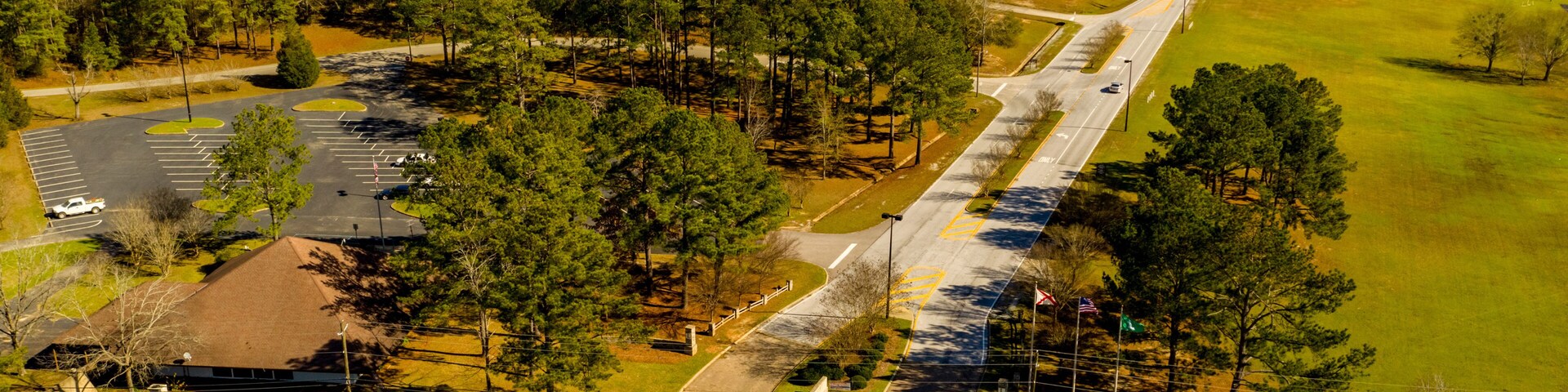 Vista aérea de una intersección de caminos rodeada de bosque denso y campos abiertos.