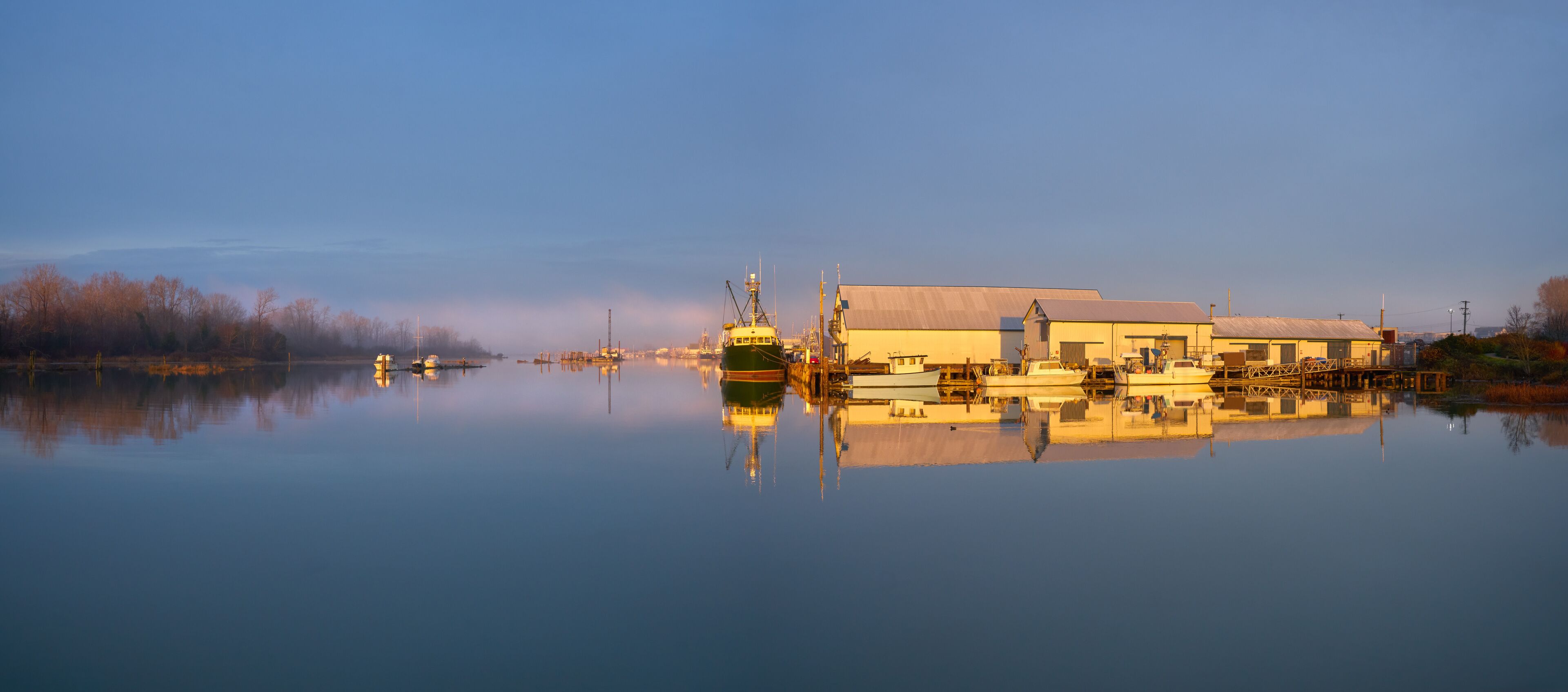 London Landing Sunrise Light Morning Docks. Commercial Fishboats tied to the docks at London Landing in Steveston Harbour on a misty sunrise morning at high tide. 

