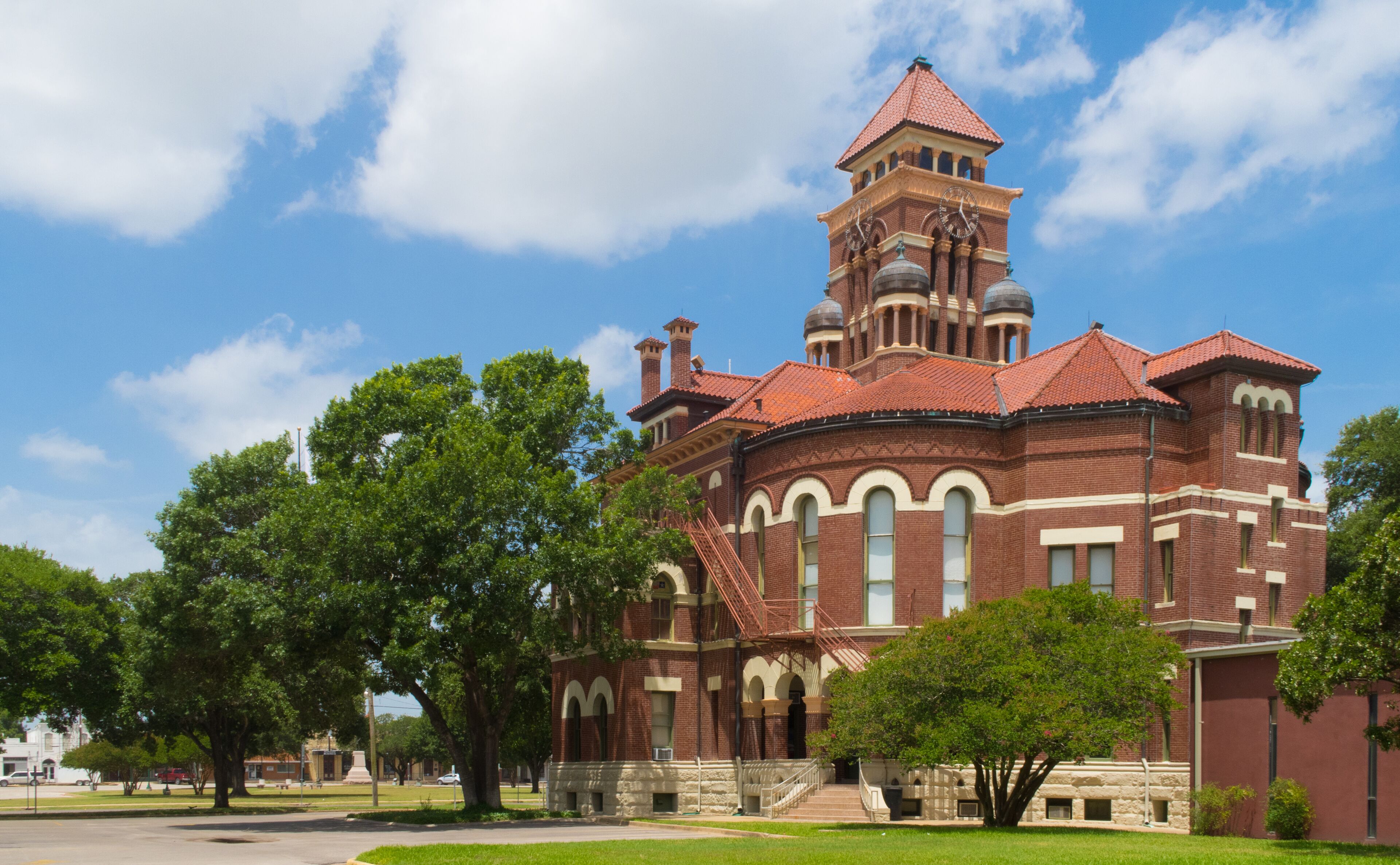 A large brick building with a clock tower and arched windows.