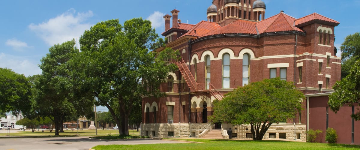 A large brick building with a clock tower and arched windows.