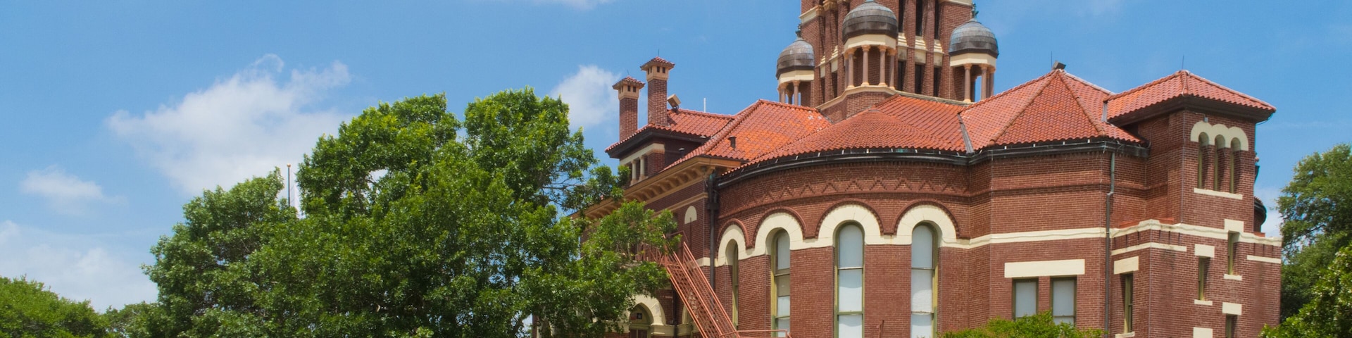A large brick building with a clock tower and arched windows.