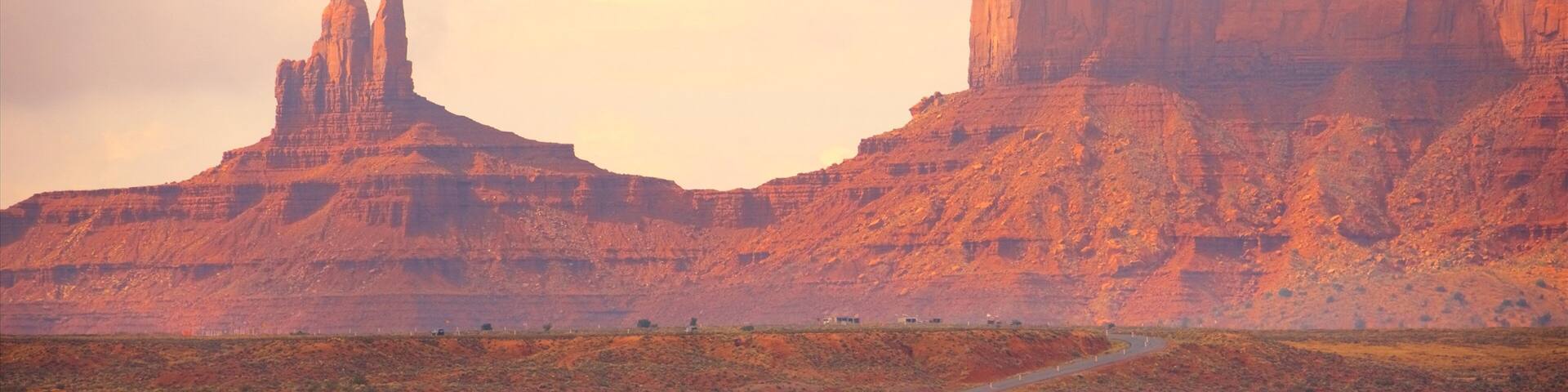 A winding road through a desert landscape with red rock formations.