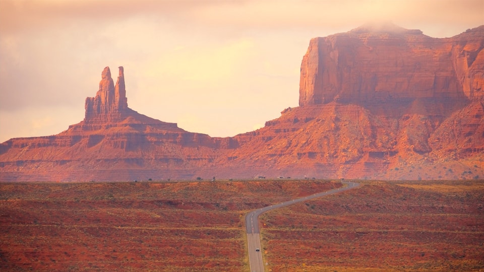 A winding road through a desert landscape with red rock formations.