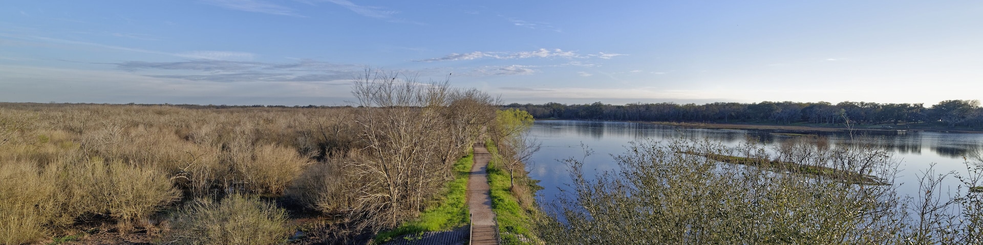 Looking down the straight Trail passing 40 Acre lake at the Brazos Bend State Park on a sunny evening in March.