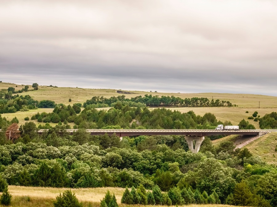 Semi-trailer truck crossing bridge along Nebraska Highway 12, also known as Outlaw Trail Scenic Byway, outside Valentine, Nebraska, USA, on a cloudy day in summer; Shutterstock ID 1482824018