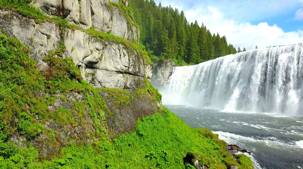Mesa Falls, Idaho, USA - Wide Waterfalls Surrounded By Green Pine Trees With A Rainbow