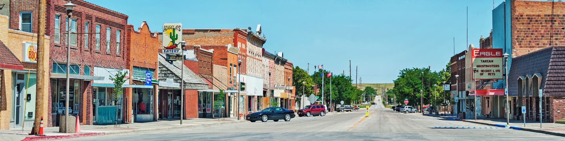A street with buildings, traffic lights, and cars.