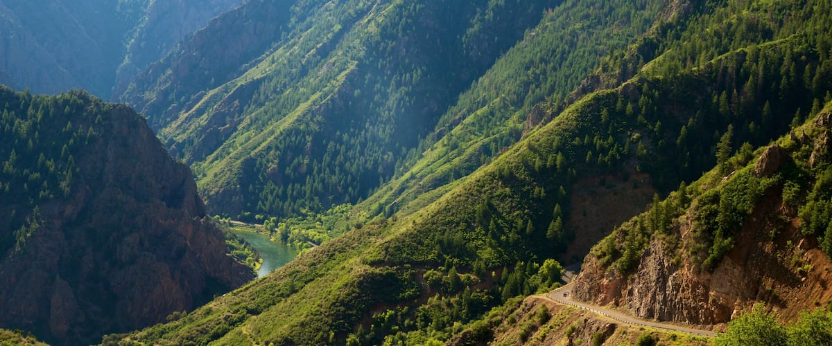 A mountainous landscape with a winding road and a river.