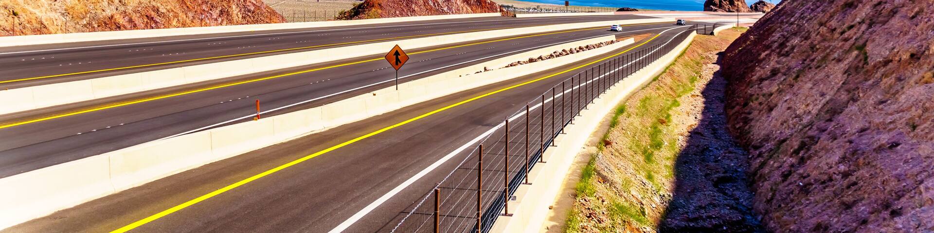 Highway 93 as it dips down to the Mike O' Callaghan-Pat Tillman Memorial Bridge over the Colorado River at the Hoover Dam on the border of the states of Nevada and Arizona