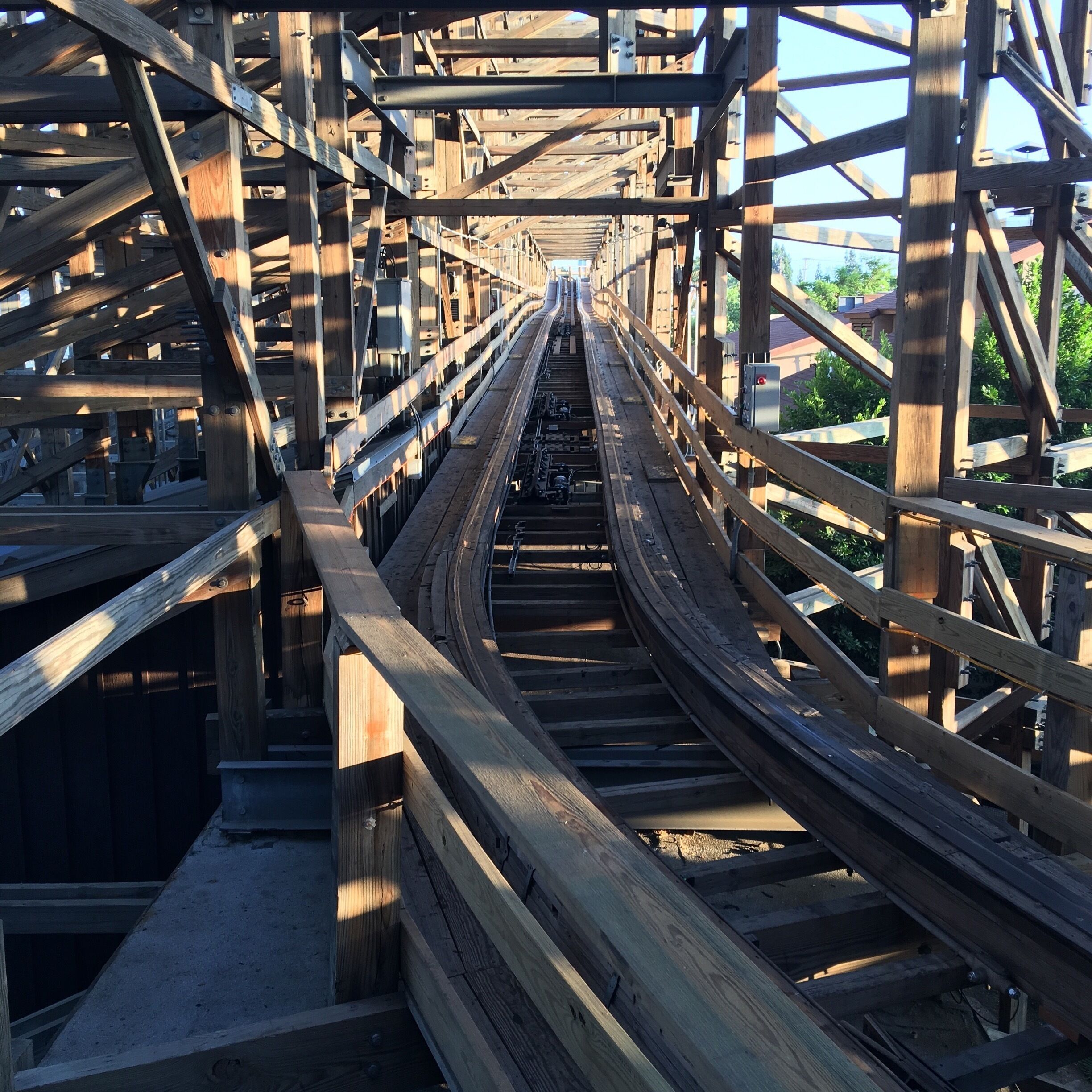 A wooden pedestrian bridge with a metal railing and a concrete walkway.