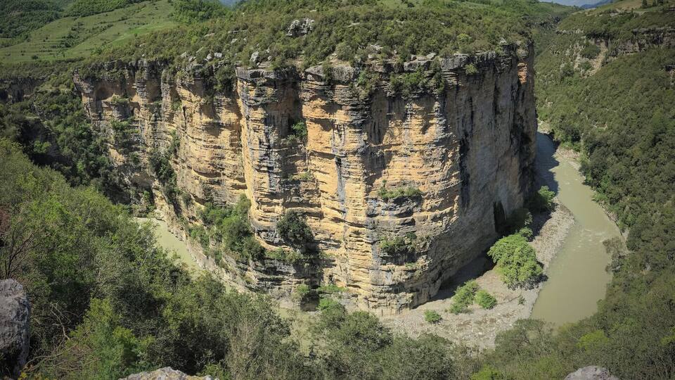 A canyon with steep cliffs and a river.