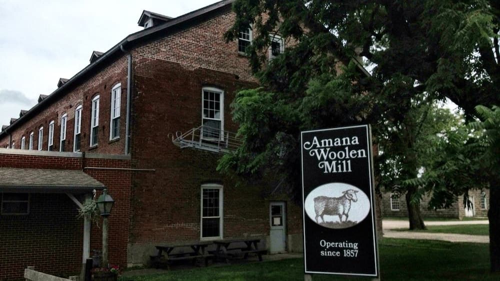 Un bâtiment en briques sur lequel on peut lire l’inscription suivante : « Amana Woolen Mill, en activité depuis 1857. »