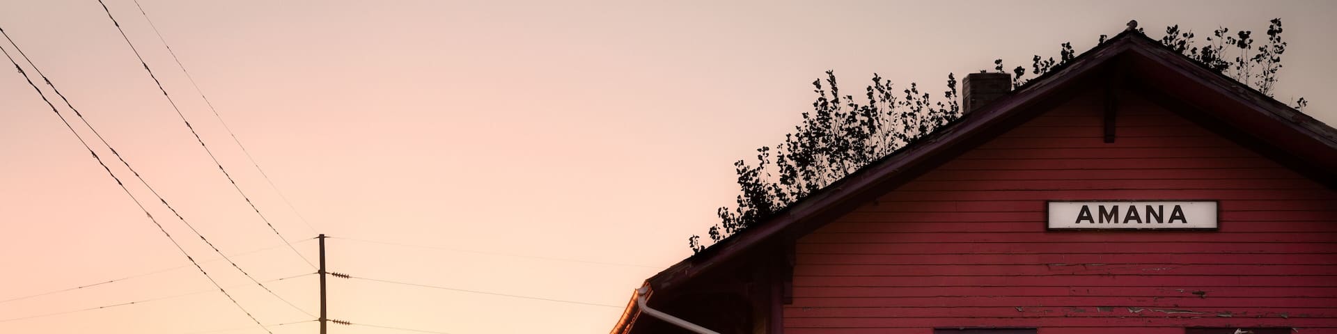 Wooden train depot with the text Amana by the railroad