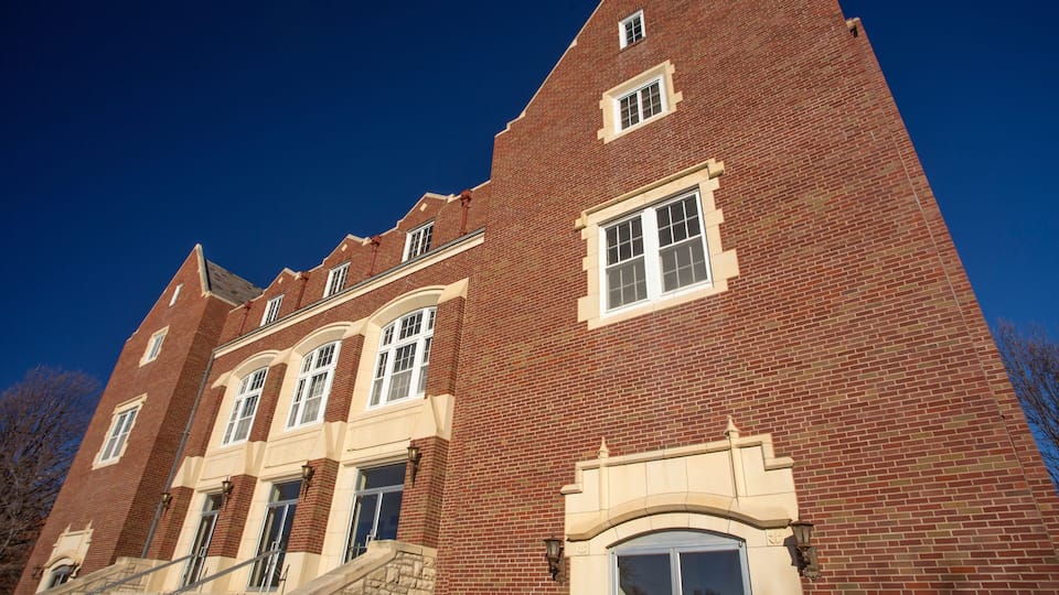 A red brick building with a stone staircase, large windows, and a clear blue sky.