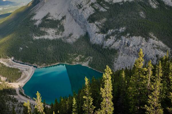A mountain with a lake at its base, surrounded by dense forest.