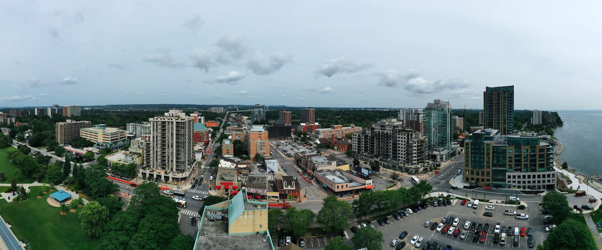 A coastal cityscape with a river, green parks, and various buildings including high-rises and mid-rise structures.