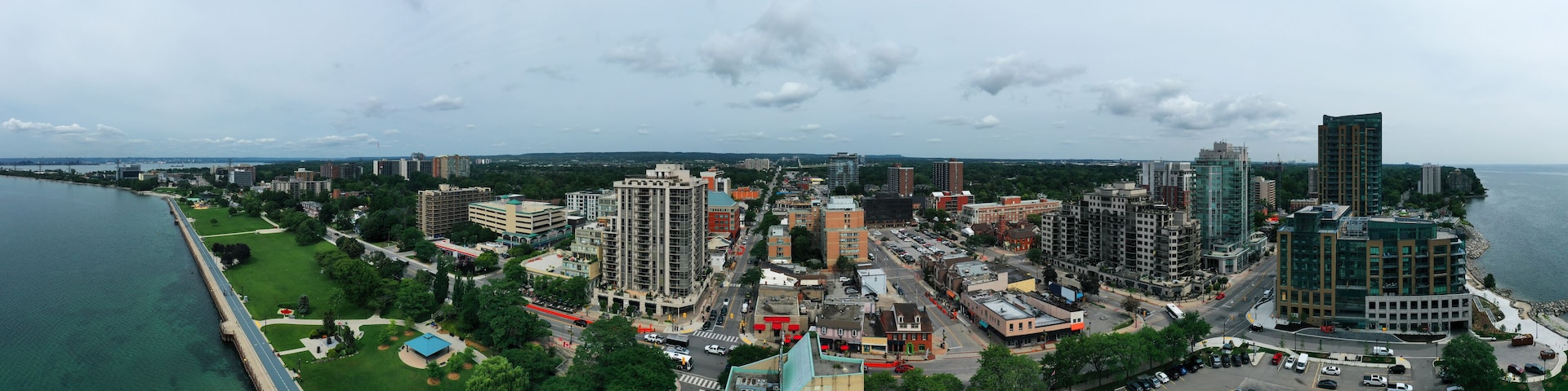 A coastal cityscape with a river, green parks, and various buildings including high-rises and mid-rise structures.