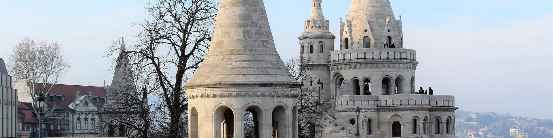 Fisherman's Bastion is a terrace in neo-Gothic and neo-Romanesque style situated on the Buda bank of the Danube, on the Castle hill in Budapest, around Matthias Church. It's seven towers represent the seven Magyar tribes that settled in the Carpathian Basin in 895. It was designed and built between 1895 and 1902 on the plans of Frigyes Schulek. Between 1947â48, the son of Frigyes Schulek, JĂĄnos Schulek, conducted the other restoration project after its near destruction during World War II.
My favorite place in Budapest! I took this photo in March 2018. And it's merely one part of the Fisherman's Bastion.