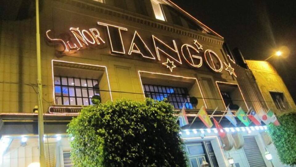 Ein Gebäude mit beleuchteter Schrifttafel mit der Aufschrift 'SENORTE TANGO' bei Nacht.