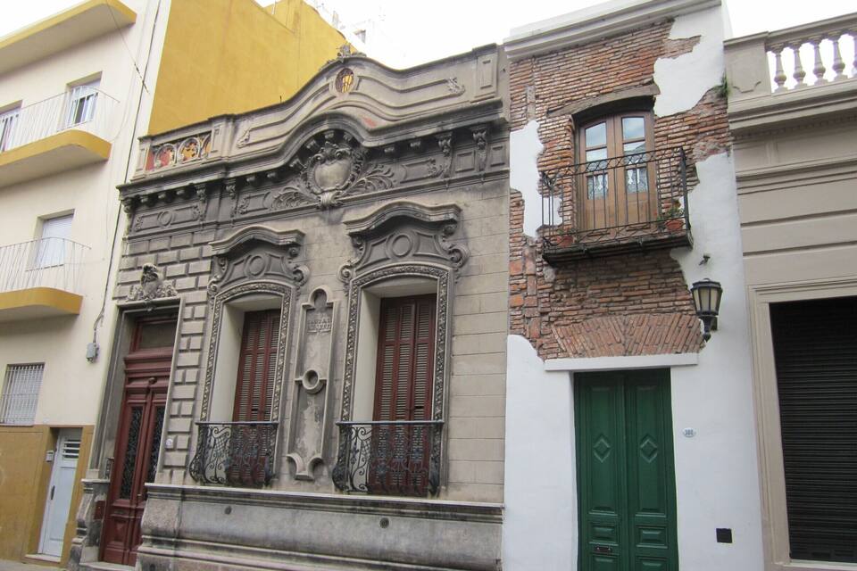 A historic building with ornate architectural details, a green door, and a yellow awning.