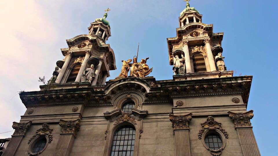 A historic building with ornate architecture, including statues and columns.