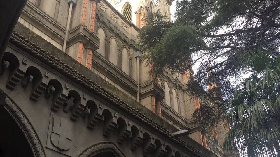 Ein historisches Gebäude mit verzierten Bögen und einem Uhrturm.