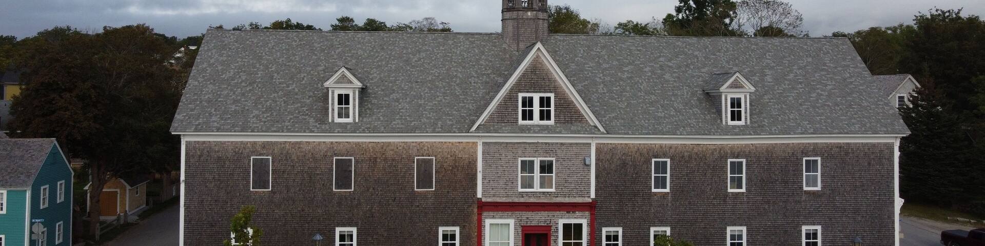 A large brick building with a red door and a steeple.