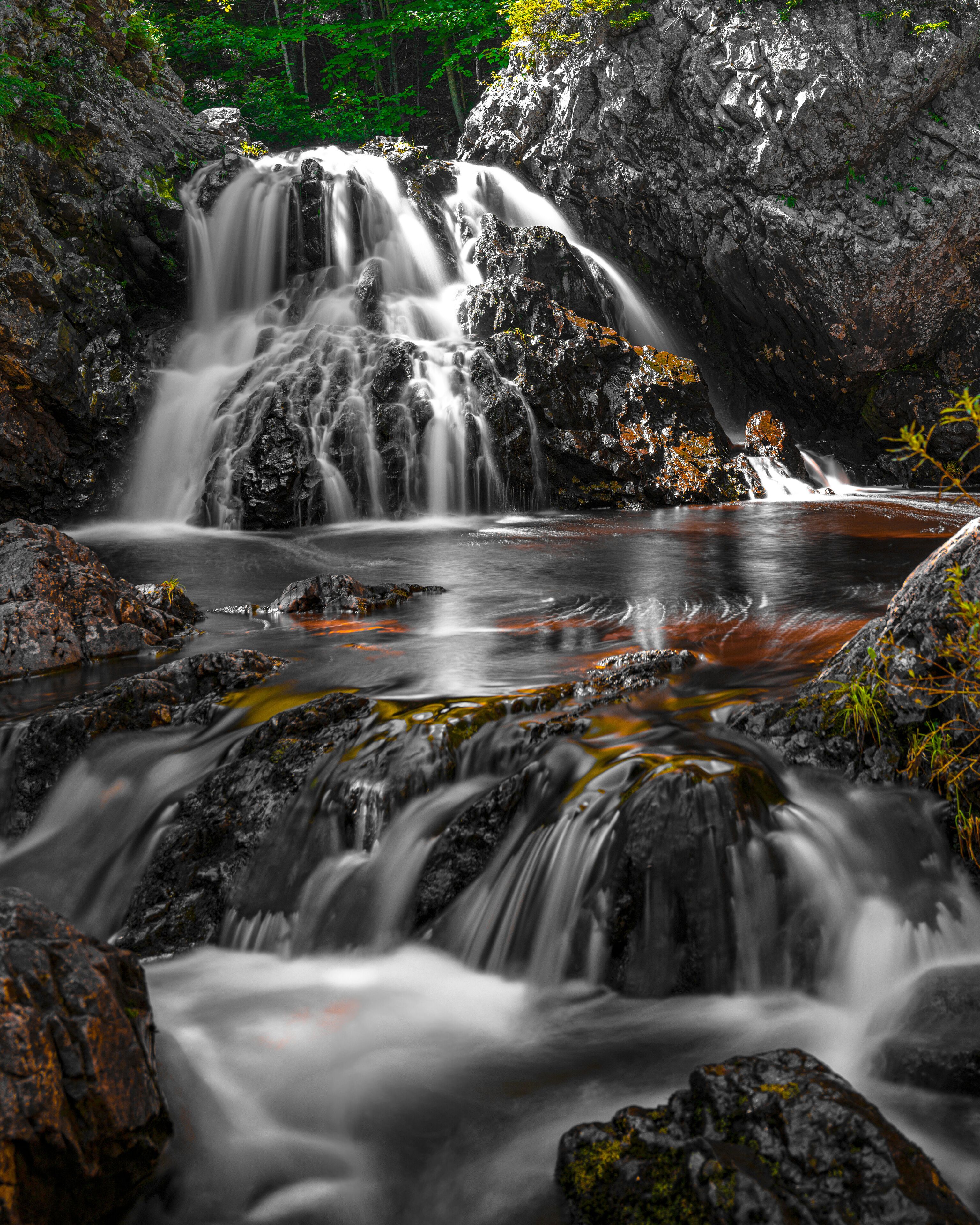 A waterfall cascading over rocks into a river.