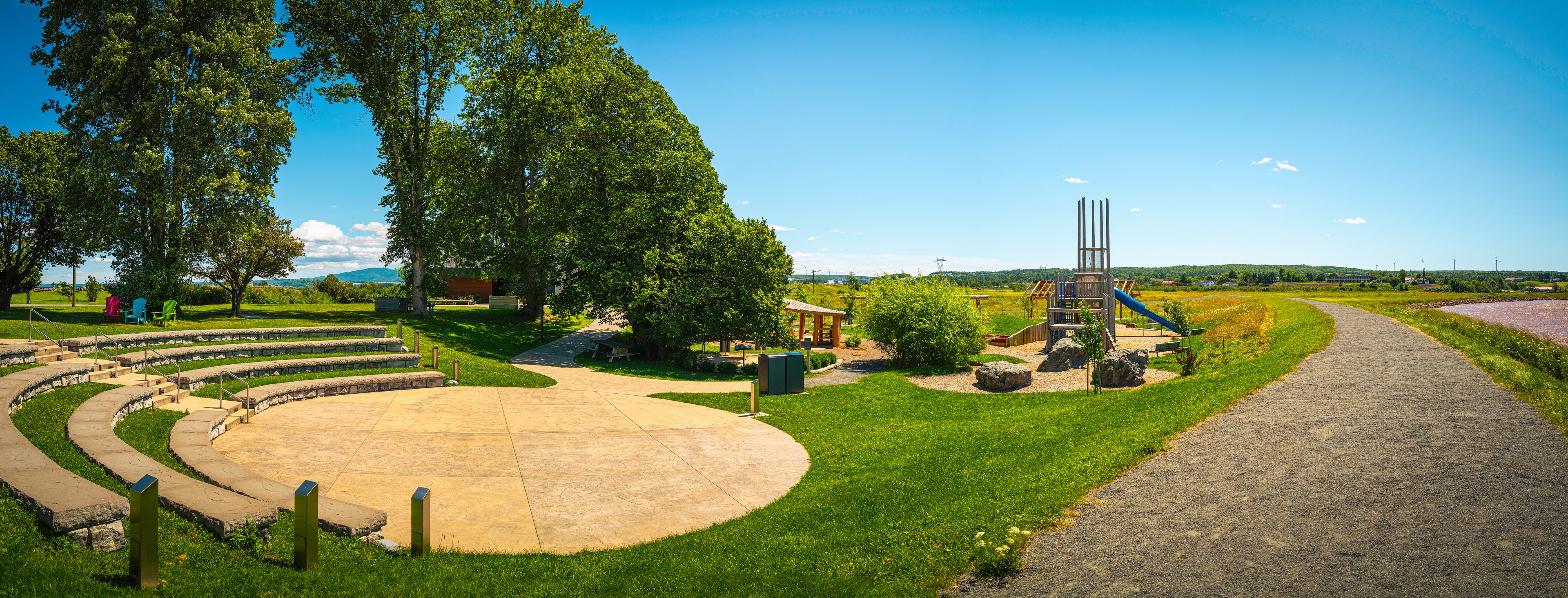 A park with a playground, a circular seating area, and a winding path.