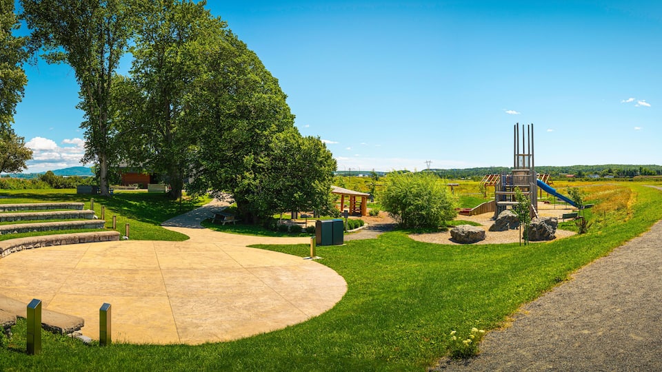 A park with a playground, a circular seating area, and a winding path.