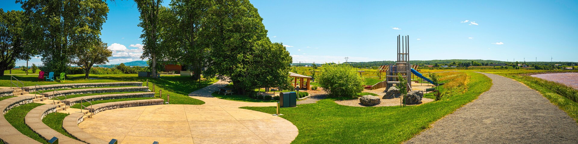 Um parque com parquinho, área de estar circular e caminho sinuoso.