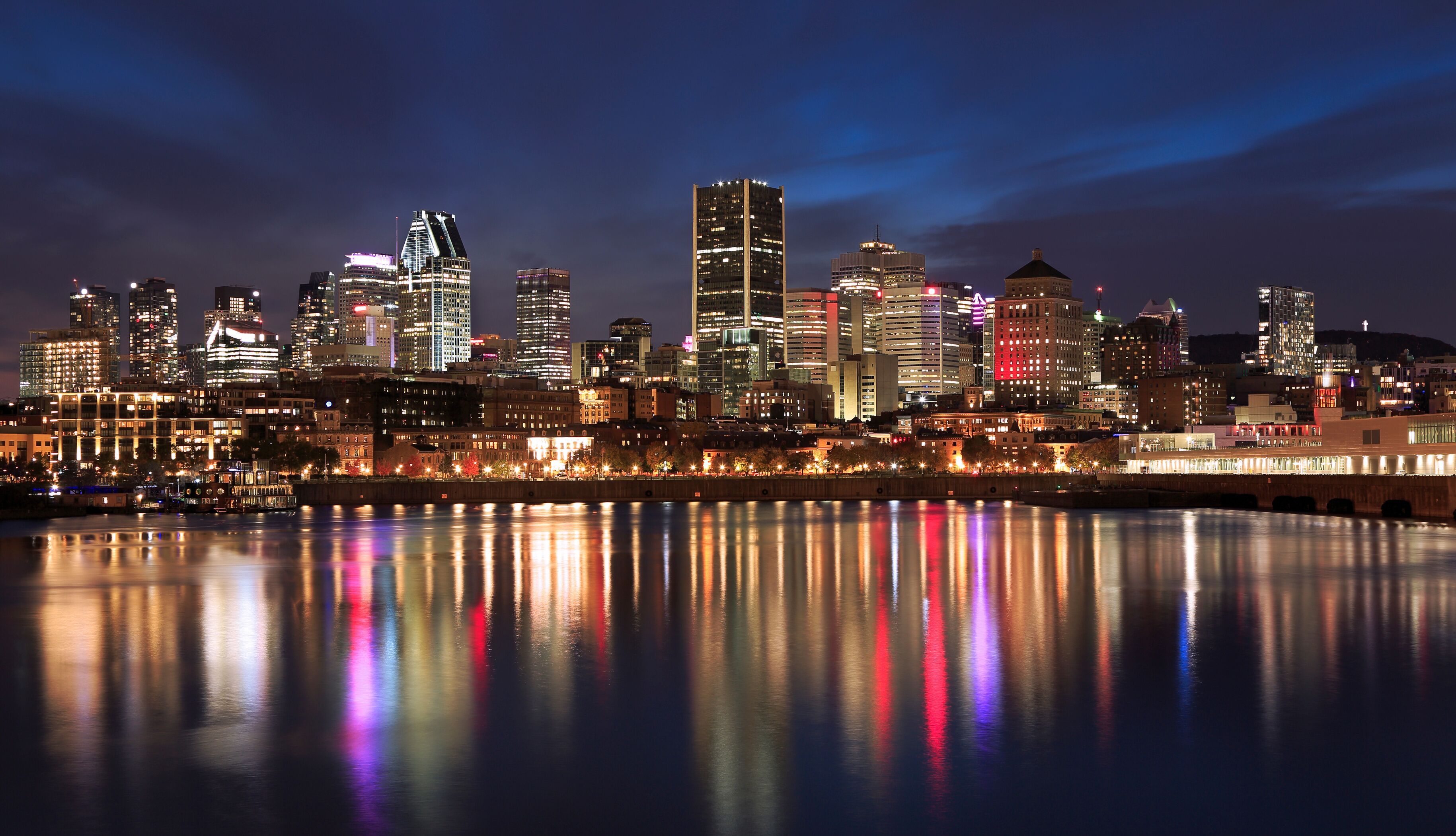 Montreal skyline illuminated at night with nice reflections in Saint Lawrence River, Quebec, Canada